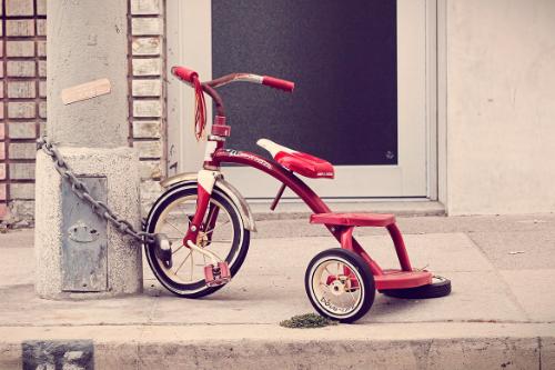 Triciclo de ni&ntilde;o encadenado a un poste