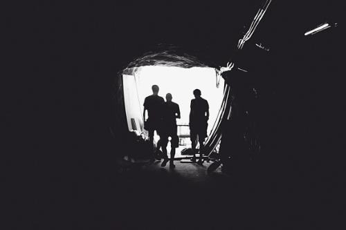 Tres personas saliendo de una cueva